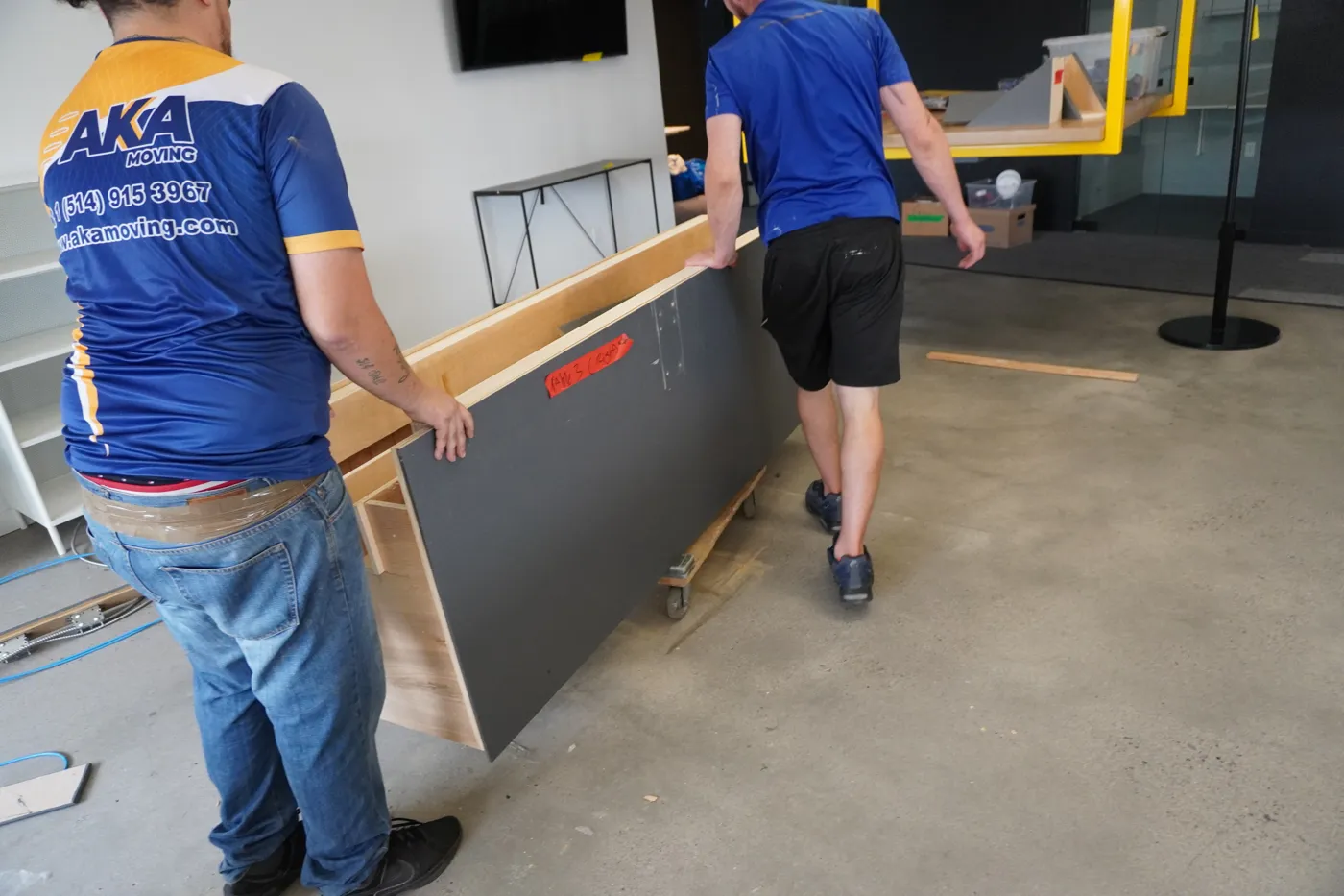 Équipe AKA Moving transportant une base de table démontée lors d’un déménagement de bureau à Montréal